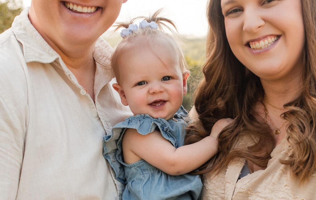 Parents holding baby with soft golden hour light in Texas Hill Country

