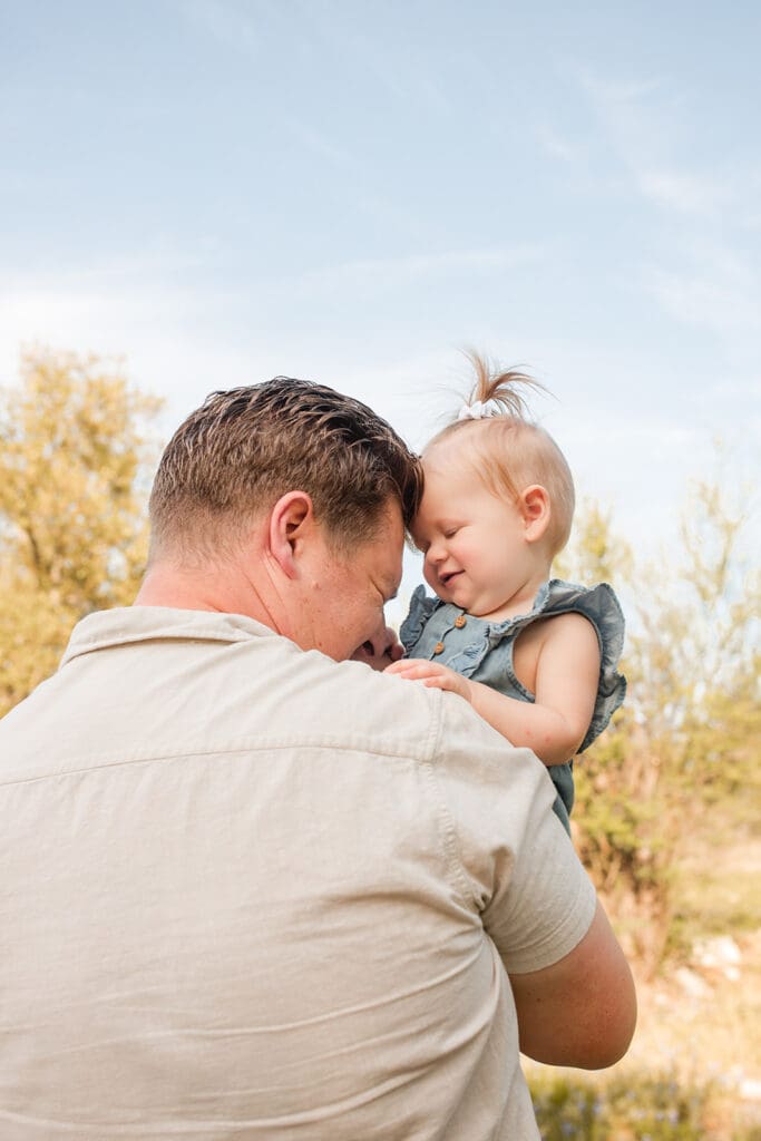 Father and child laughing together during lifestyle family session in Texas

