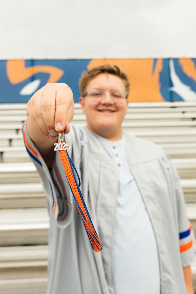 Joyful high school graduate holding 2025 tag in Spring, Texas