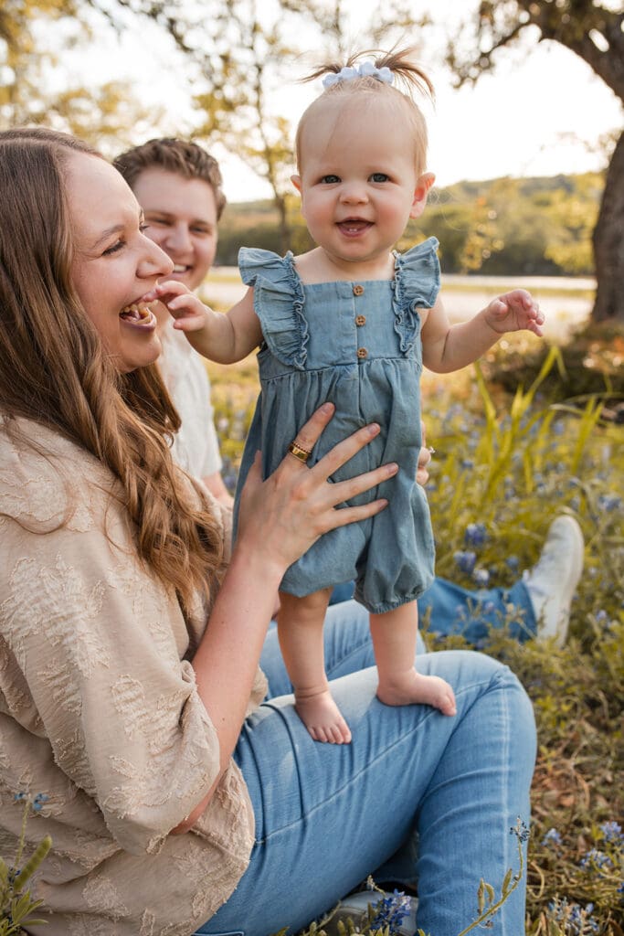 Mother holding baby in a field of wildflowers near Bulverde
